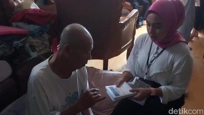 Petugas KPPS di Manado, Sulut, membantu warga yang sakit mencoblos di rumah karena tidak bisa ke TPS.