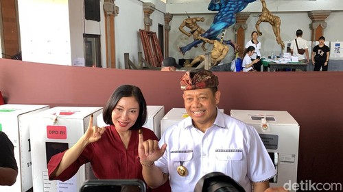 Pj Gubernur Bali Sang Made Mahendra Jaya dan istrinya Ida Setiawati Mahendra Jaya menunjukkan tanda tinta di jari kelingking seusai memilih di TPS 009 Banjar Kayumas Kaja, Denpasar, Rabu (14/2/2024).