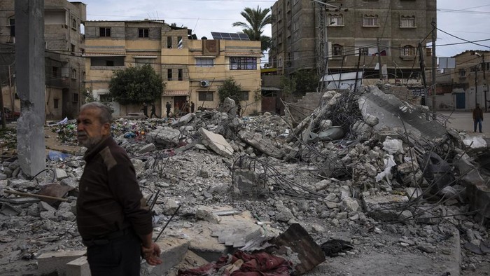 Neighbors inspect the rubble of the Hasouna family house, which was struck by an Israeli airstrike during an operation to rescue two hostages in Rafah, southern Gaza Strip, Tuesday, Feb. 13, 2024. Ibrahim Hasouna, who was away at the time of the airstrike, says his entire family was killed, including his parents, two brothers, his sister-in-law and three nieces and nephews. (AP Photo/Fatima Shbair)