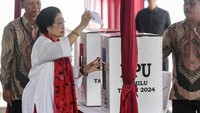 Setelah beberapa menit melakukan pencoblosan di bilik suara, Megawati berjalan ke kotak suara untuk memasukkan surat suara.