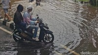 Beberapa pengendara motor nekat menerobos banjir.