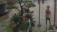 Anak-anak memanfaatkan banjir untuk bermain.