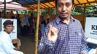 Seorng warga menunjukkan tinta kunyit di jarinya usai mencoblos di TPS Kampung Benda Kerep Kota Cirebon. Penggunaan tinta kunyit ini upaya dalam merawat tradisi masyarakat. Foto: Ony Syahroni/detikJabar
