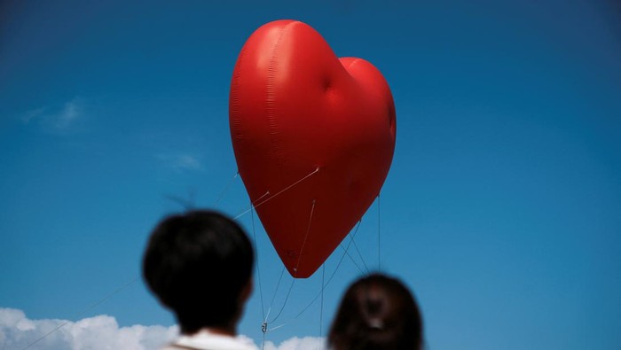 Visitors pose for pictures with a giant inflatable heart called 