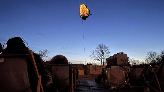 Swiss artist Alain Roche plays the piano hanging from a crane during a concert in Munich, Germany, February 5, 2024.     REUTERS/Louisa Off     TPX IMAGES OF THE DAY