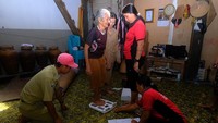 Petugas kesehatan dari Puskesmas Pembantu (Pustu) Sungai Utik juga menimbang berat badan warga lansia.