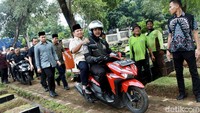 Prabowo pun turun dari mobil lalu menuju makam dibonceng motor matic berwarna merah.