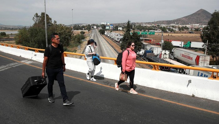 Aksi Sopir Truk Blokir Jalan Utama di Meksiko Protes Kriminalitas Striking truck drivers block a highway in Jorobas to protest lawlessness on the roads that has led to a rise in robberies and extortion, in Jorobas, State of Mexico, Mexico February 15, 2024. REUTERS/Henry Romero