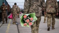 Prajurit Ukraina dengan bunga menunggu kereta dari Kyiv, di tengah serangan Rusia ke Ukraina, di stasiun kereta di Kramatorsk, Ukraina 14 Februari 2024. REUTERS/Inna Varenytsia