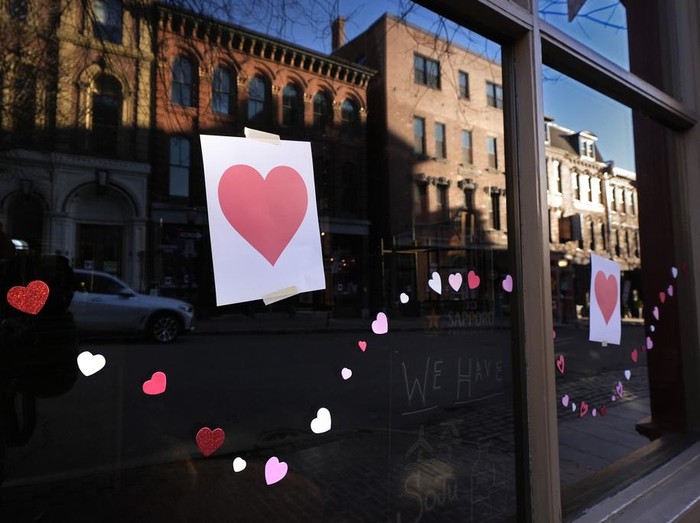 Valentines Day Hearts decorate a storefront on Exchange Street, Wednesday, Feb. 14, 2024, in Portland, Maine. The public has helped honor the memory of Kevin Fahrman, the Valentines Day Bandit who secretly hung hundreds of red paper hearts throughout the city every February 14th. Farman died last year. (AP Photo/Robert F. Bukaty)