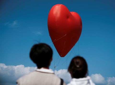 Visitors look at a giant inflatable heart called 