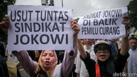 Massa aksi kompak membawa atribut seperti poster selama aksi berlangsung.