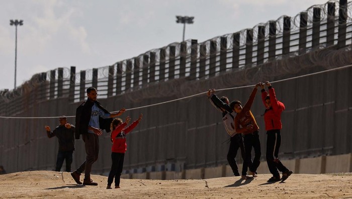 Displaced Palestinian children, who fled their houses due to Israeli strikes, look through a window, as they take shelter at the border with Egypt, amid the ongoing conflict between Israel and the Palestinian Islamist group Hamas, in Rafah in the southern Gaza Strip, February 15, 2024. REUTERS/Ibraheem Abu Mustafa