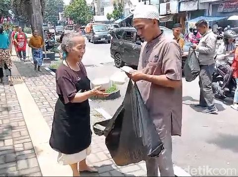 Pembagian nasi bungkus oleh relawan pendukung Gibran, Progi, di Pasar Legi, Kota Solo, Jumat (16/2/2024).