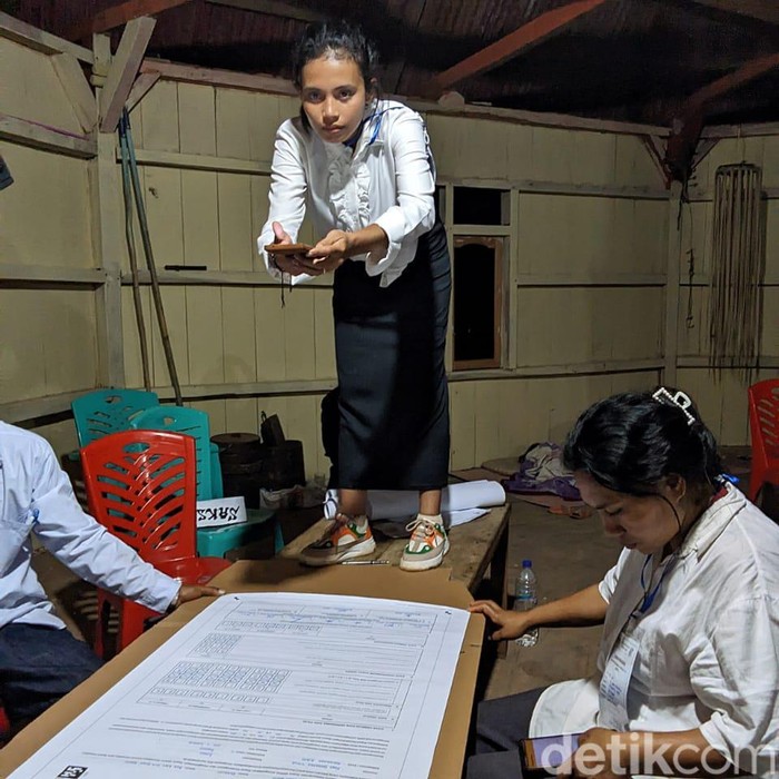 Petugas KPPS di Desa Pangga, Kecamatan Kuwus, Manggarai Barat, NTT, berdiri di atas meja mencari sinyal internet untuk unggah hasil pemungutan suara ke Sirekap (Istimewa)