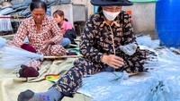 Pekerja membuat sapu plastik di sebuah gudang di Phnom Penh, Kamboja, Kamis (15/2/2024).  