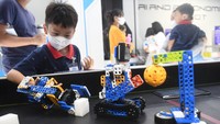 Seorang anak menggunakan tangan robot saat mengunjungi pameran robotic di Robopark Indonesia, Pluit Village Mall, Jakarta.