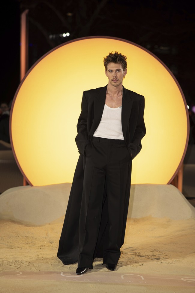 Para pria pun tak kalah memukau. Austin Butler mengandalkan kombinasi kaus, coat panjang, dan celana high-waist dari Gucci. (Foto: Vianney Le Caer/Invision/AP)