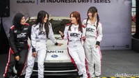 Drifter wanita berbincang bersama di depan mobil.