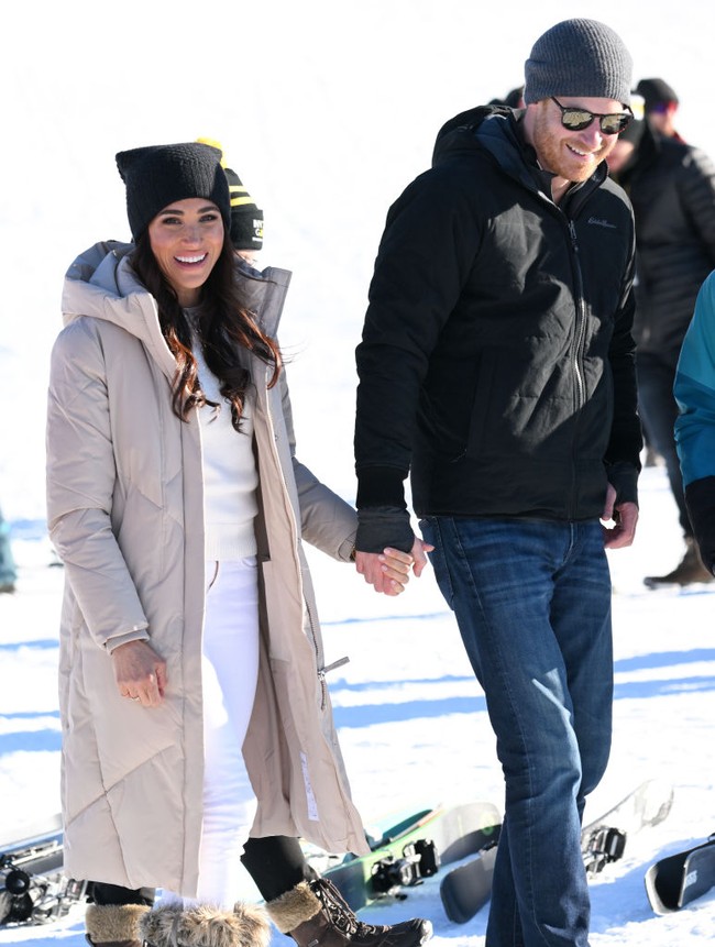 Pangeran Harry dan Meghan Markle mengenakan pakaian musim dingin yang tebal saat berada di tempat dengan suhu di bawah titik beku. Sambil bergandengan tangan mereka berjalan untuk berbicara dengan para atlet ski.Foto: Getty Images/Karwai Tang