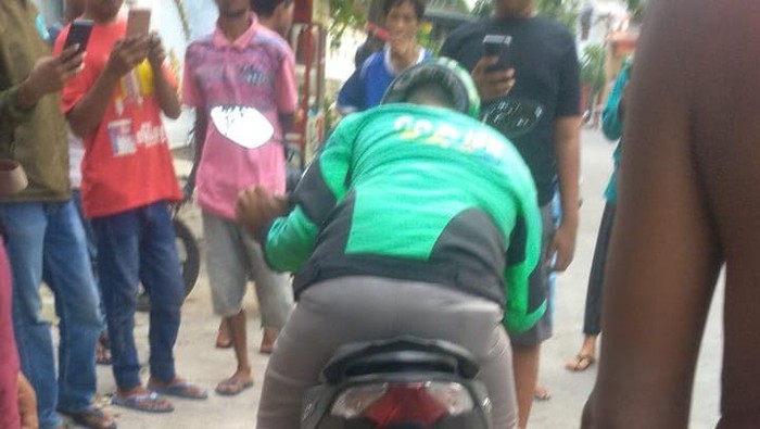 Pengemudi ojol meninggal dunia di atas sepeda motor.
