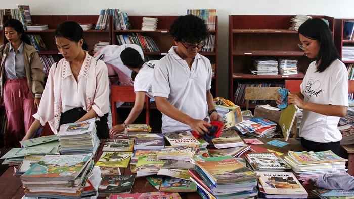 Relawan penggiat literasi membersihkan buku saat kegiatan Donasi Literasi di SDN Tumbang Nusa 2, Kabupaten Pulang Pisau, Kalimantan Tengah, Sabtu (17/2/2024). Komunitas Donasi Literasi melakukan kegiatan bedah perpustakaan mulai dari membersihkan buku, penataan ulang buku, dan penyaluran donasi buku untuk perpustakaan SDN Tumbang Nusa 2 sebagai upaya meningkatkan daya minat baca dan literasi kepada pelajar di sekolah tersebut. ANTARA FOTO/Auliya Rahman/Spt.