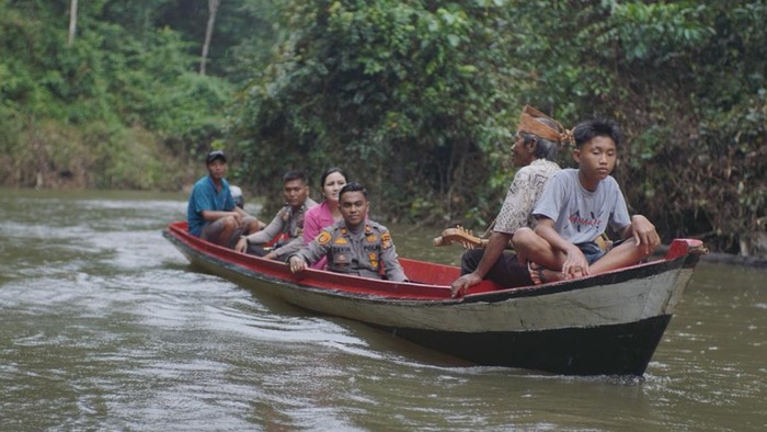 Kapolsek saat pakai perahu bersama istri menuju suku pedalaman, yakni Talang Mamak (Dok Humas Polres Inhu)