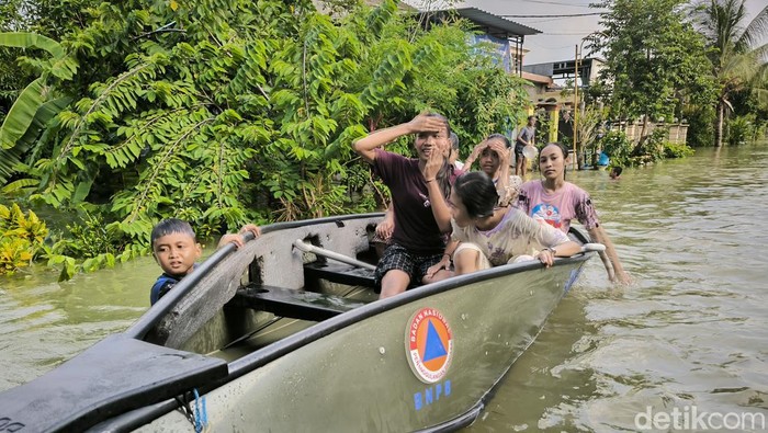 Anak-anak di Gresik memanfaatkan perahun BPBD untuk bermain saat banjir datang