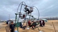 Anak-anak Gaza bermain ayunan di lokasi pengungsian, 18 Februari 2024.