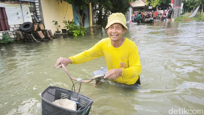 Warga di Desa Ngablak, Gresik menerobos banjir