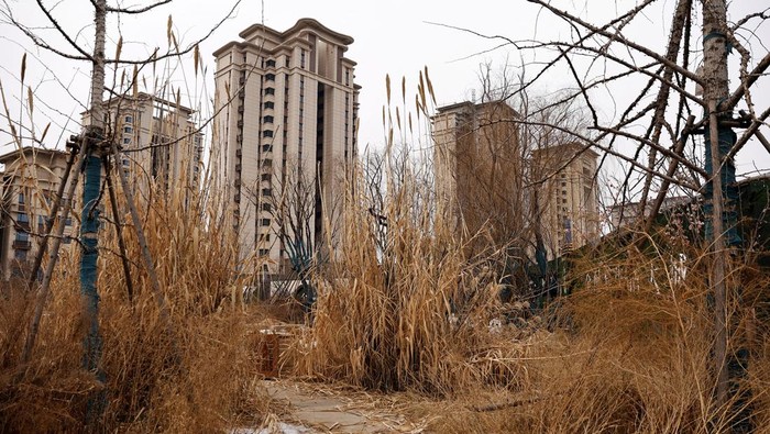 CHINA-PROPERTY/DEBT-EVERGRANDE A man walks past unfinished residential buildings developed by China Evergrande Group in the outskirts of Shijiazhuang, Hebei province, China February 1, 2024. REUTERS/Tingshu Wang