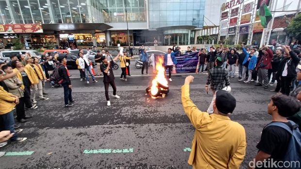 Aliansi mahasiswa Banyumas Raya menggelar aksi dengan membakar ban menyuarakan sistem demokrasi pada pemerintahan Presiden Jokowi di kompleks Alun-alun Purwokerto, Senin (19/2/2023)