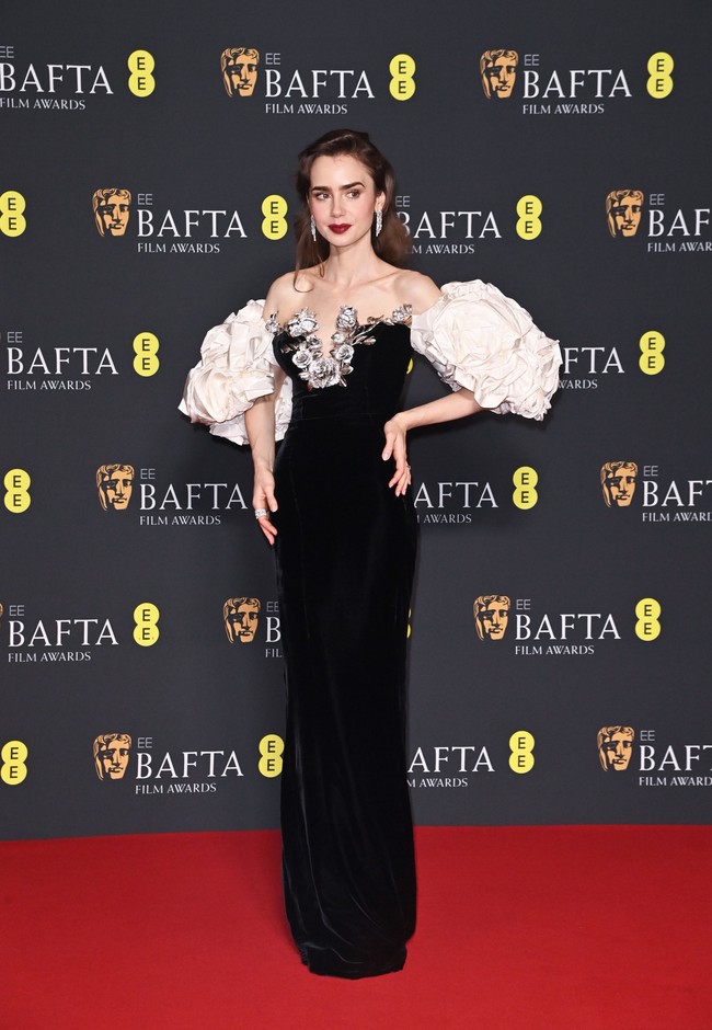 Blooming everywhere. Gaun off-shoulder Tamara Ralph yang dihiasi dekorasi bunga mawar tiga dimensi menjadi andalan aktris Lily Collins. (Foto: Alan Chapman/Getty Images)