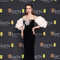 Blooming everywhere. Gaun off-shoulder Tamara Ralph yang dihiasi dekorasi bunga mawar tiga dimensi menjadi andalan aktris Lily Collins. (Foto: Alan Chapman/Getty Images)