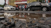 Pengendara menghindari jalan rusak di Jalan Raya Mayor Oking, Cibinong, Kabupaten Bogor, Jawa Barat, Senin (19/2/2024).