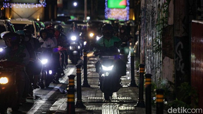 Lalin Macet, Pemotor Bajak Trotoar di Fatmawati Pesepeda motor menerobos trotoar di Jalan Fatmawati, Jakarta Selatan, Senin (19/2/2024). Lalu-lintas di lokasi terpantau macet pukul 19.00 WIB.