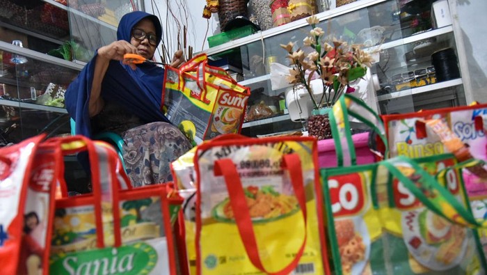 Perajin membuat kerajinan tas berbahan sampah plastik di Belawan, Medan, Sumatera Utara, Senin (19/2/2024). Produk kerajinan yang memanfaatkan limbah sampah plastik, kulit jagung dan kertas koran menjadi barang bernilai ekonomi seperti tas, jam, vas bunga itu dijual Rp5.000 hingga Rp350.000. ANTARA FOTO/Fransisco Carolio/aww.