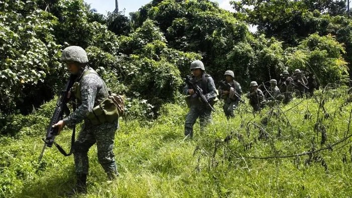 Philippine marines conduct a clearing operation near the site where weapons and ISIS flags were recovered following a November 26 firefight with members of a criminal gang. (AFP)