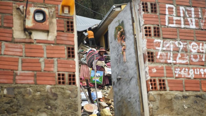 Neighbours and residents look at the damage after landslides caused by rains that buried houses and left fatalities, in Achocalla, Bolivia February 17, 2024. REUTERS/Claudia Morales