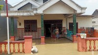 Seorang warga di Desa Munggugianti sedanng membersihakn rumahnya yang terendam banjir luapan Kali Lamong.