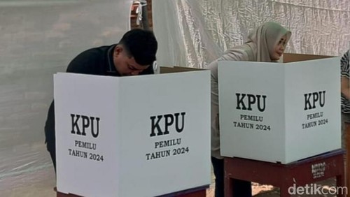 M Putera Ferryandi bersama ibunya, Bupati Bima, Indah Dhamayanti Putri saat memberikan hak pilih Pemilu 2024 di Kota Bima, NTB. (Rafiin/detikBali)