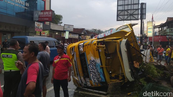 Truk AD 8386 KC bermuatan pohon aren yang mengalami kecelakaan di Jalan Salaman-Purworejo di Krasak, Salaman, Kabupaten Magelang, Senin (19/2/2024).