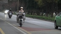 Warga berkendara di tengah cuaca dingin di Xi an, provinsi Shaanxi, China, Selasa (20/2/2024).