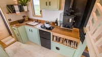 Area dapur sudah lengkap dengan area dapur yang lengkap dengan wastafel, kulkas, microwave, oven, kompor gas, dan pemanas air. Bagian atasnya juga telah terpasang rak dan lemari penyimpanan. Foto: Kurt CyberGuy Knutsson