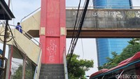 Coretan tidak jelas itu terlihat mulai menaiki tangga JPO Jalan Mayjen Sungkono.