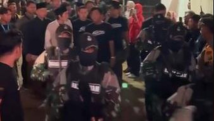 gus iqdam dikawal pasukan berseragam loreng bersenjata laras panjang