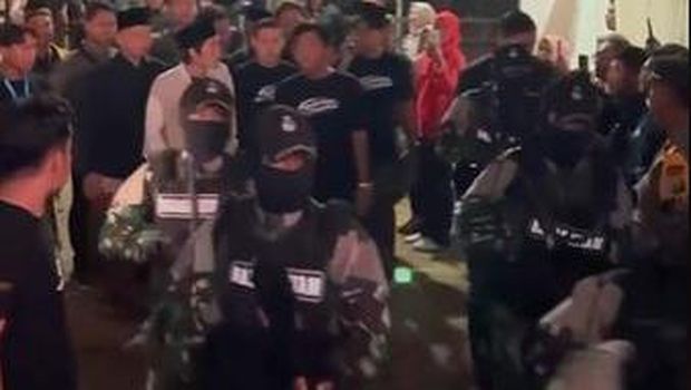 gus iqdam dikawal pasukan berseragam loreng bersenjata laras panjang