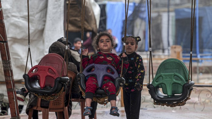 A child rides a swing in Rafah in the southern Gaza Strip on February 18, 2024, amid continuing battles between Israel and the militant group Hamas. (Photo by SAID KHATIB / AFP)