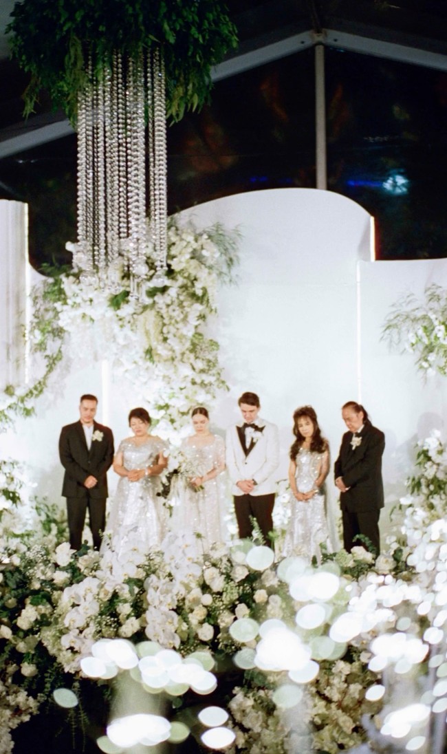 Dekorasi resepsi pernikahan Christ dan Marcella tampak mewah dan elegan bertabur bunga yang didominasi warna putih. Christ dan Marcella juga kompak mengenakan busana putih senada dengan dekorasi pernikahannya. Foto: Instagram/@christlaurent