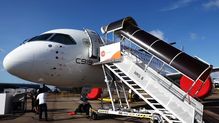 Pesawat Jet Penumpang C919 Mejeng di Singapore Airshow A Brazilian delegation poses for photos next to an Embraer C-390 Millennium aircraft during the Singapore Airshow at Changi Exhibition Centre in, Singapore, February 20, 2024. REUTERS/Edgar Su